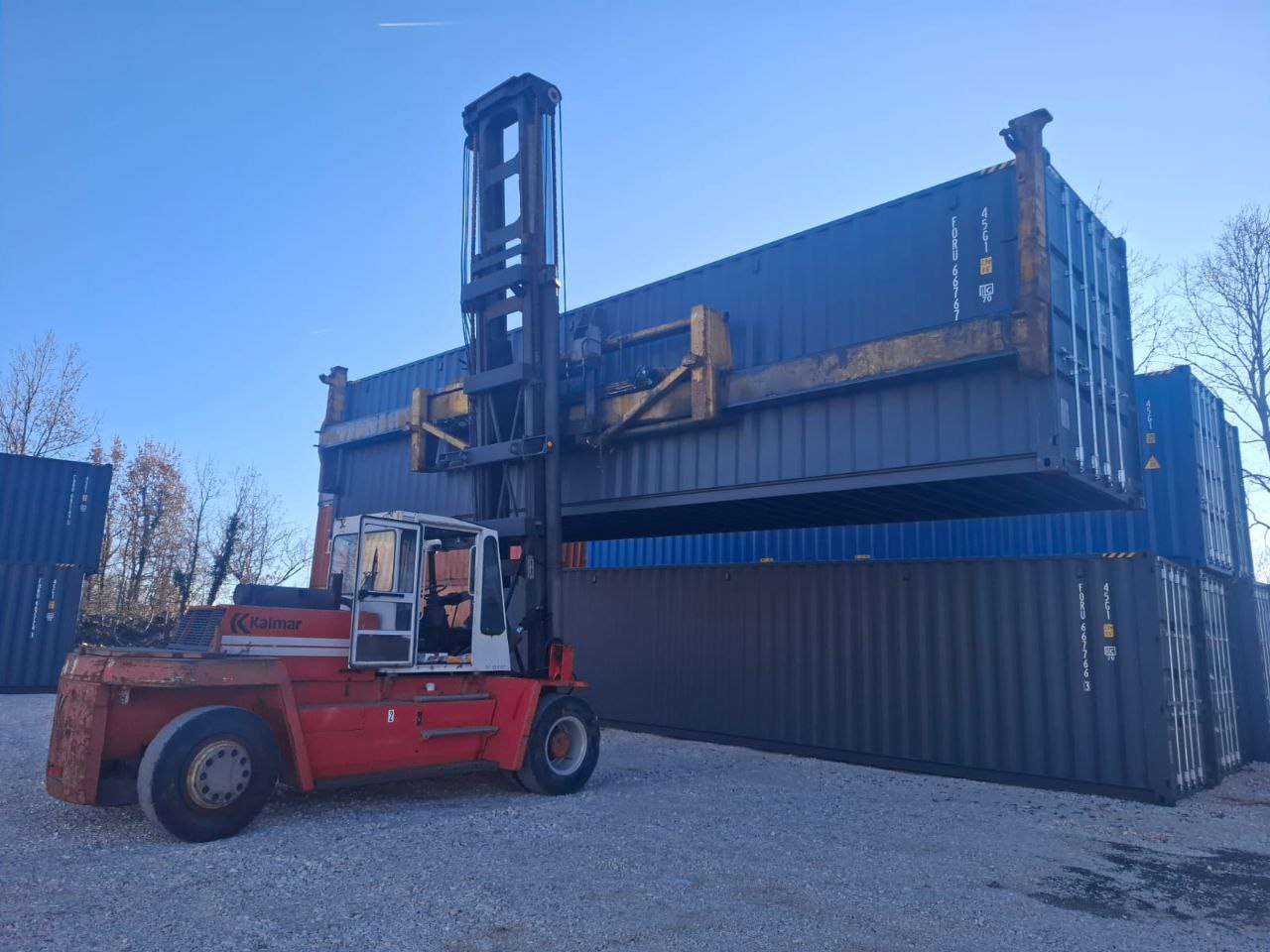 Eurotransporti heavy forklift stacking and organizing shipping containers in the yard